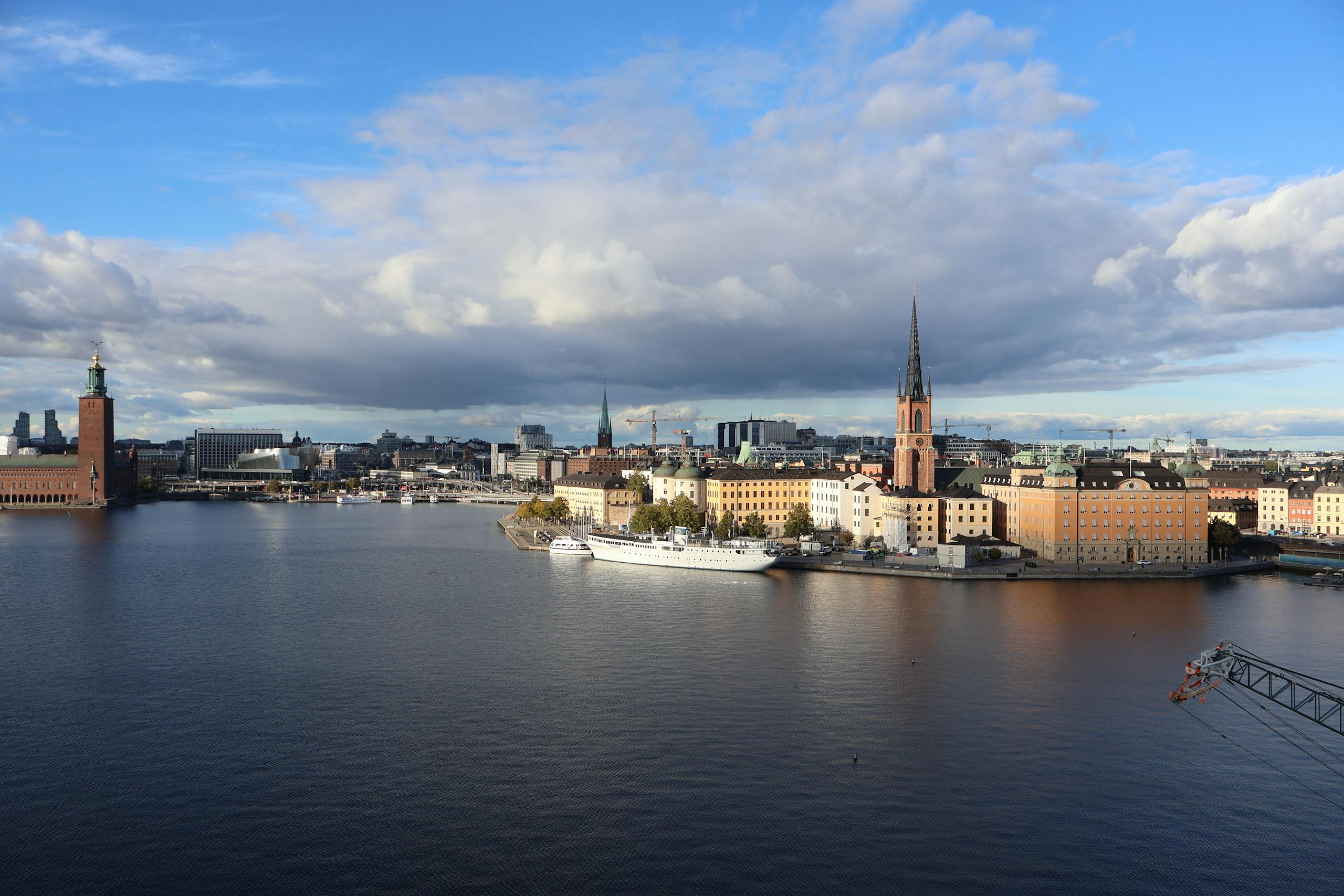 Aerial view of Stockholm's skyline with historic architecture by the waterfront under a blue sky.